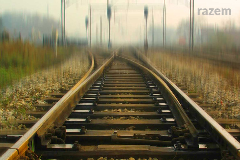 Obrazek przedstawiający puste tory kolejowe. W tle rozmazany horyzont.