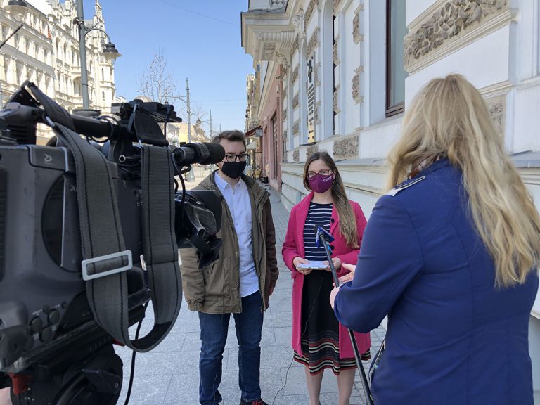Czy mieszkańcy mają kontakt z radnymi? Fotografia z konferencji prasowej na ulicy Piotrkowskiej w Łodzi. W centralnym kadrze widać: Henryk Wójtowicz i Paulina Matysiak. Na pierwszym planie widać kamerę (z lewej strony) a z prawej redaktor z mikrofonem.