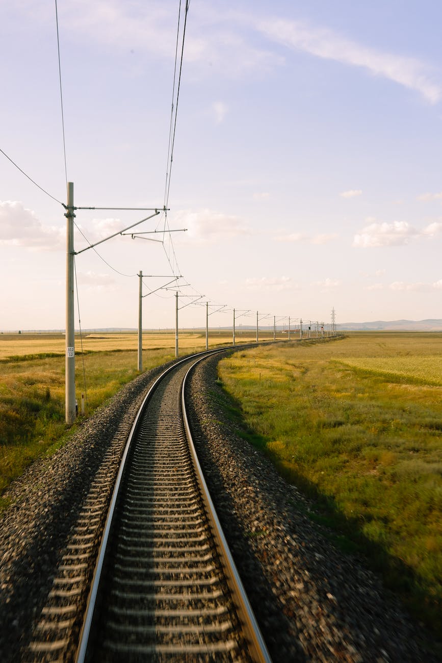 overhead lines and railway tracks on an embankment through the countryside