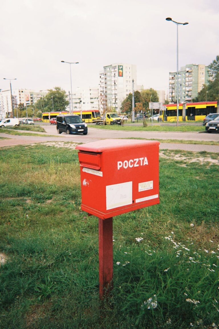red poczta mailbox on urban street in warsaw