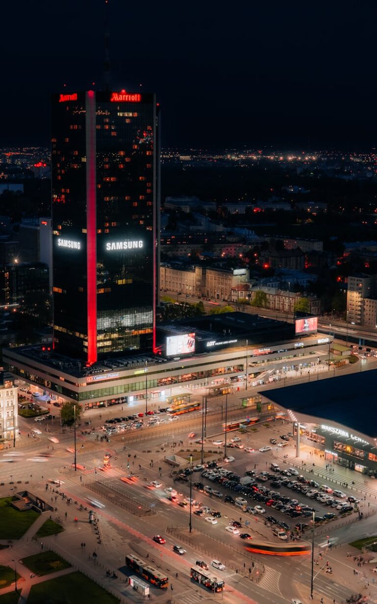 a city at night with a large building in the foreground