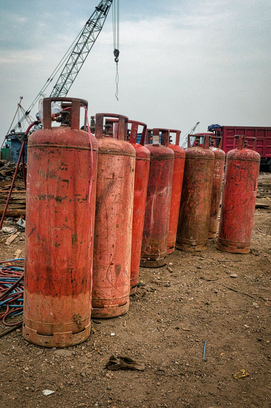 old gas tanks placed on dry ground in daytime