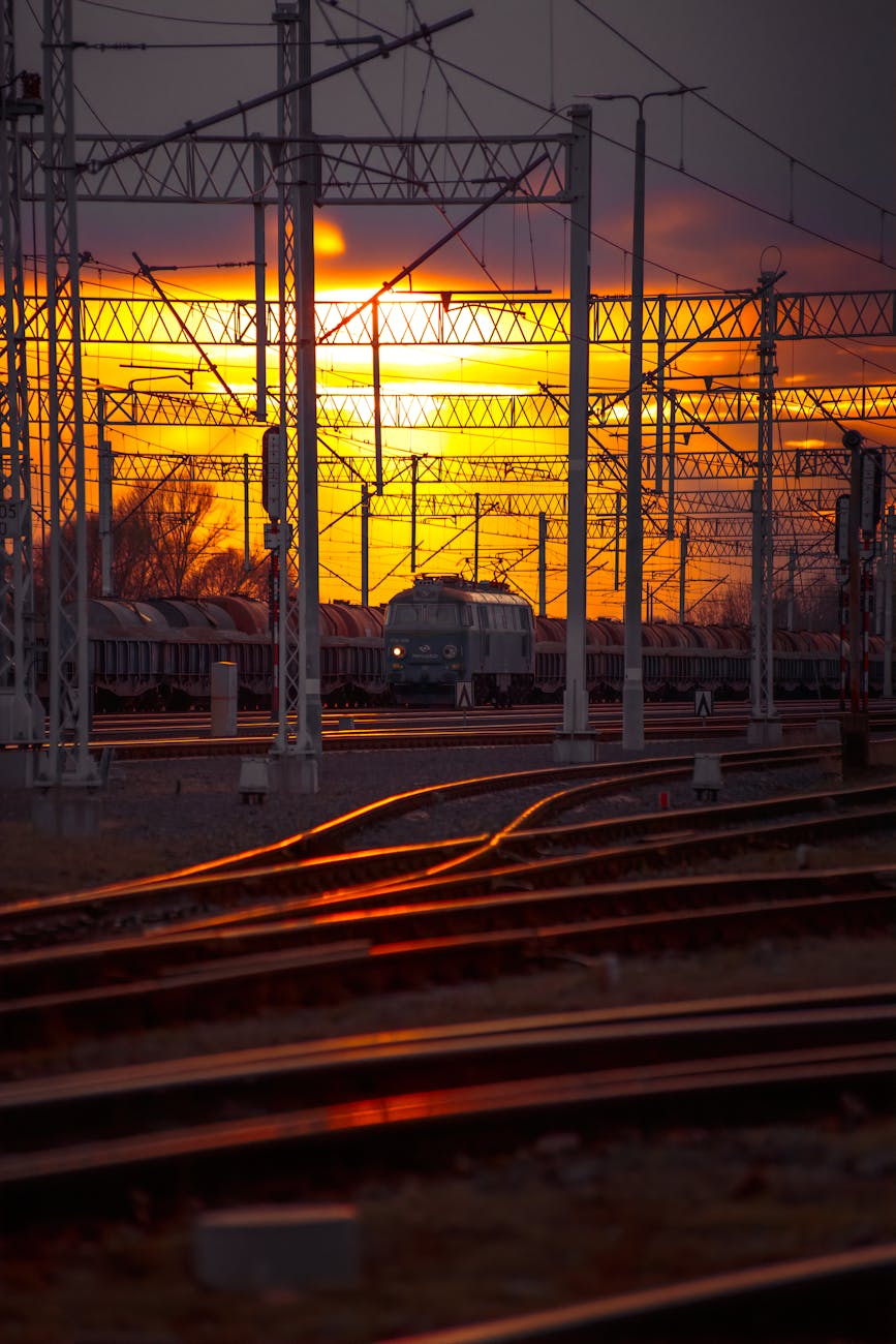 view of the railway and a cargo train in the background at sunset