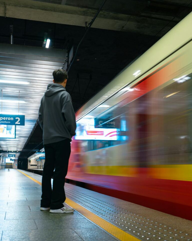 man standing near train at subway platform