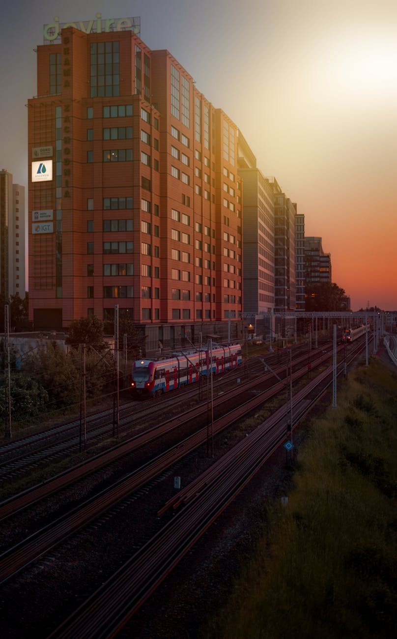 train near building in warsaw at sunset