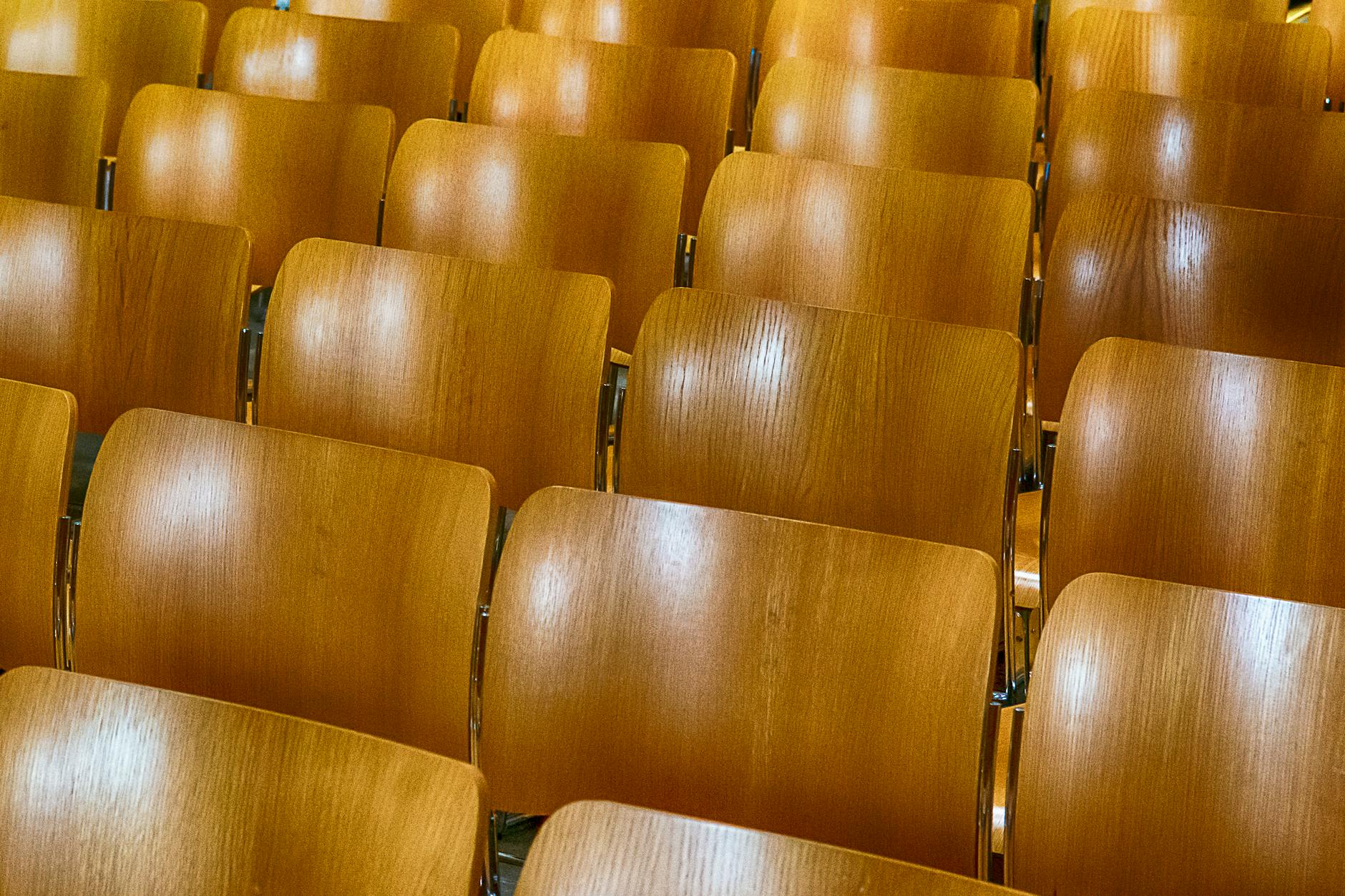 empty wooden auditorium seating rows