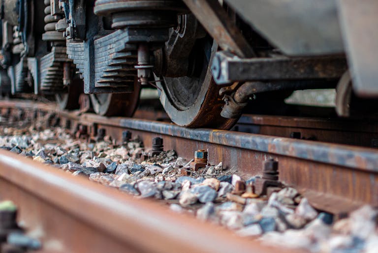 Detailed view of train wheels and rusty railway tracks with nuts and bolts.