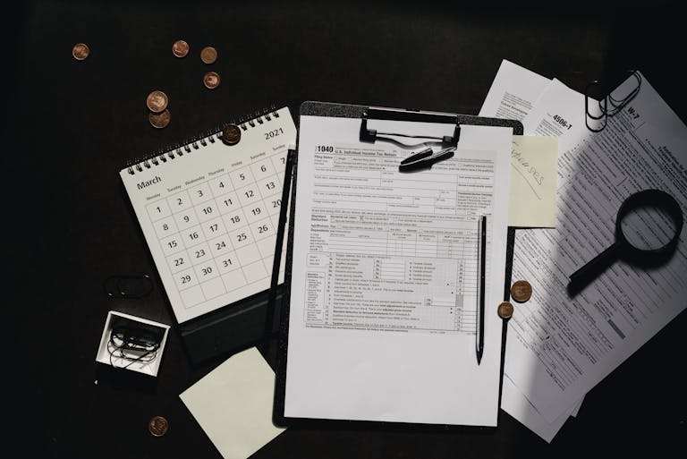 A neatly organized workspace featuring tax forms, calendar, magnifying glass, and office supplies for efficient tax preparation.