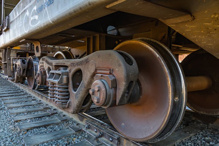 Detailed shot of rusty train wheels on a railway track, showcasing metal textures and industrial design.