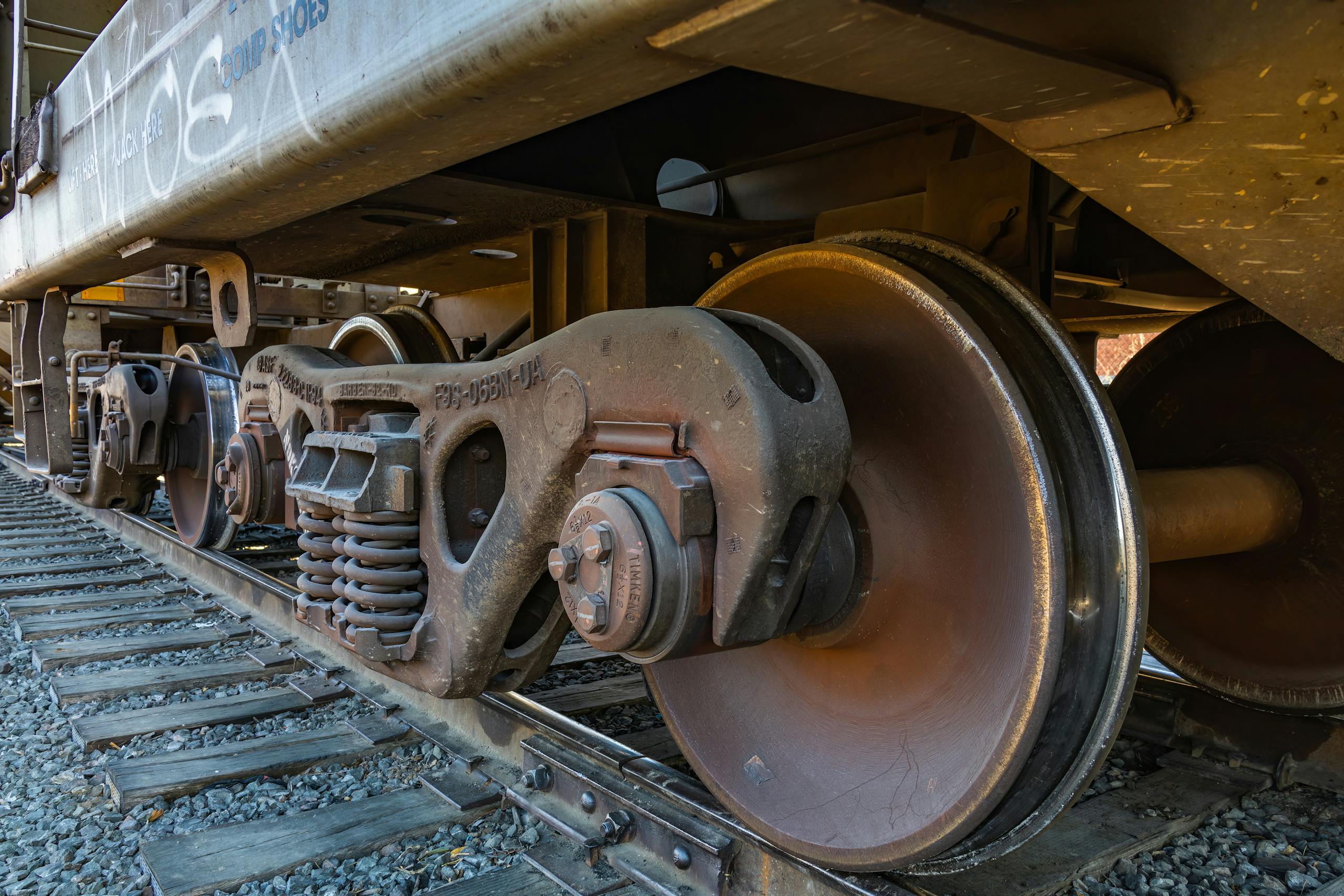 Detailed shot of rusty train wheels on a railway track, showcasing metal textures and industrial design.