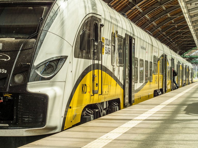 Modern yellow and white train at an indoor station platform in Dolny Śląsk, Poland.