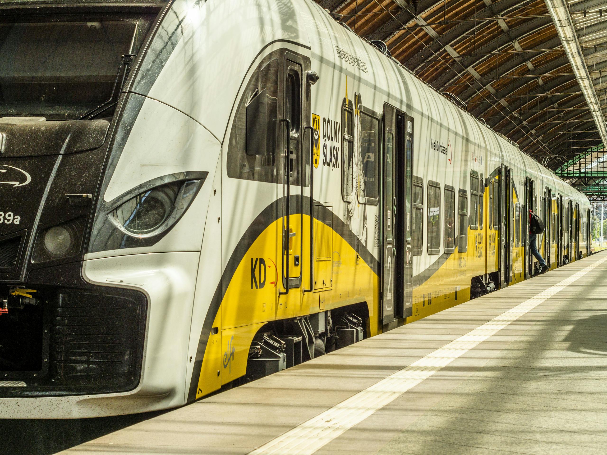 Modern yellow and white train at an indoor station platform in Dolny Śląsk, Poland.
