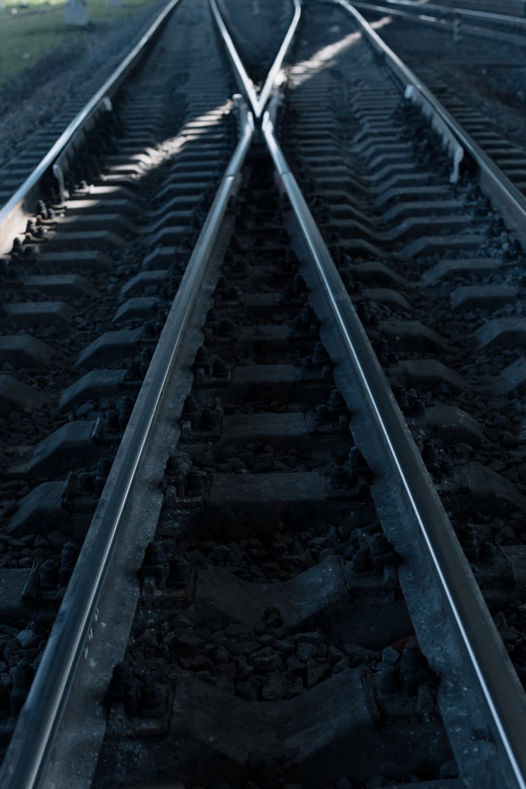 Railroad tracks converging under low light, creating a dramatic, moody effect.