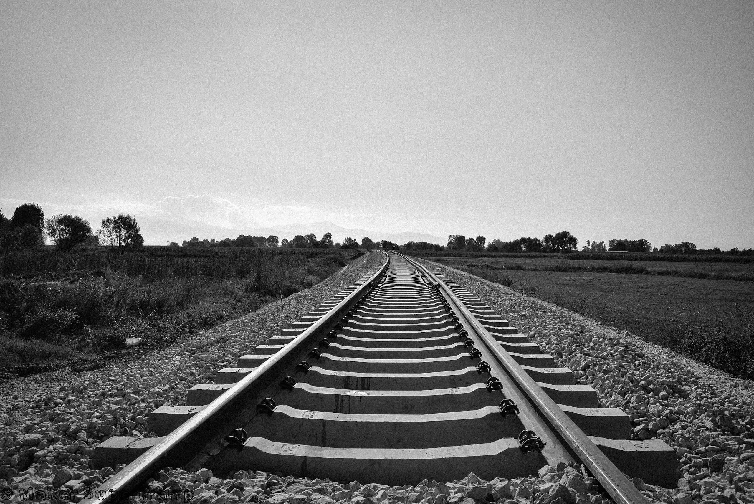 Black and white image of railway tracks stretching into the distance in the Bitola countryside, North Macedonia.