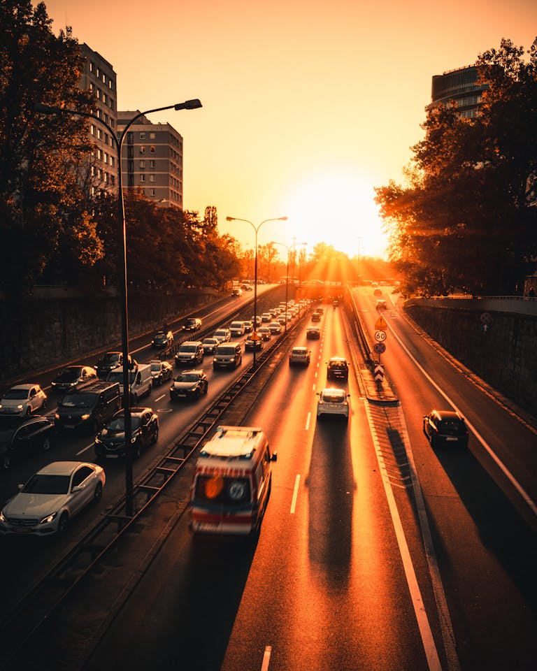 A vibrant sunset scene highlighting bustling traffic on a city expressway in Warsaw, Poland.