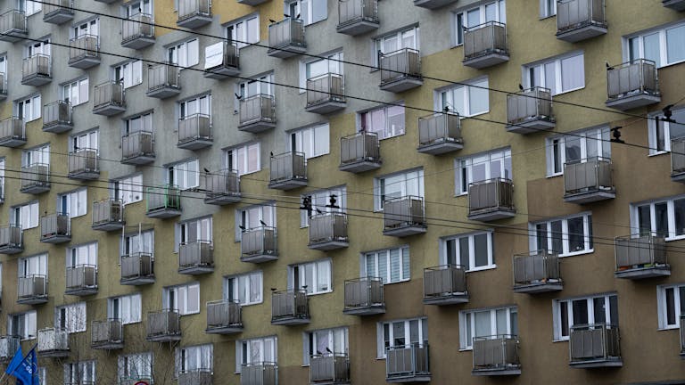 Close-up of a geometric apartment building facade in Gdynia, Poland showcasing repeating patterns and balconies.