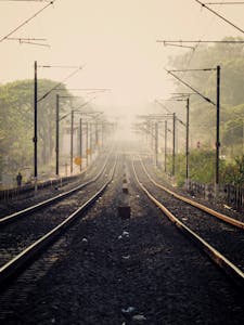 Symmetrical view of railway tracks vanishing into mist in Bengaluru.