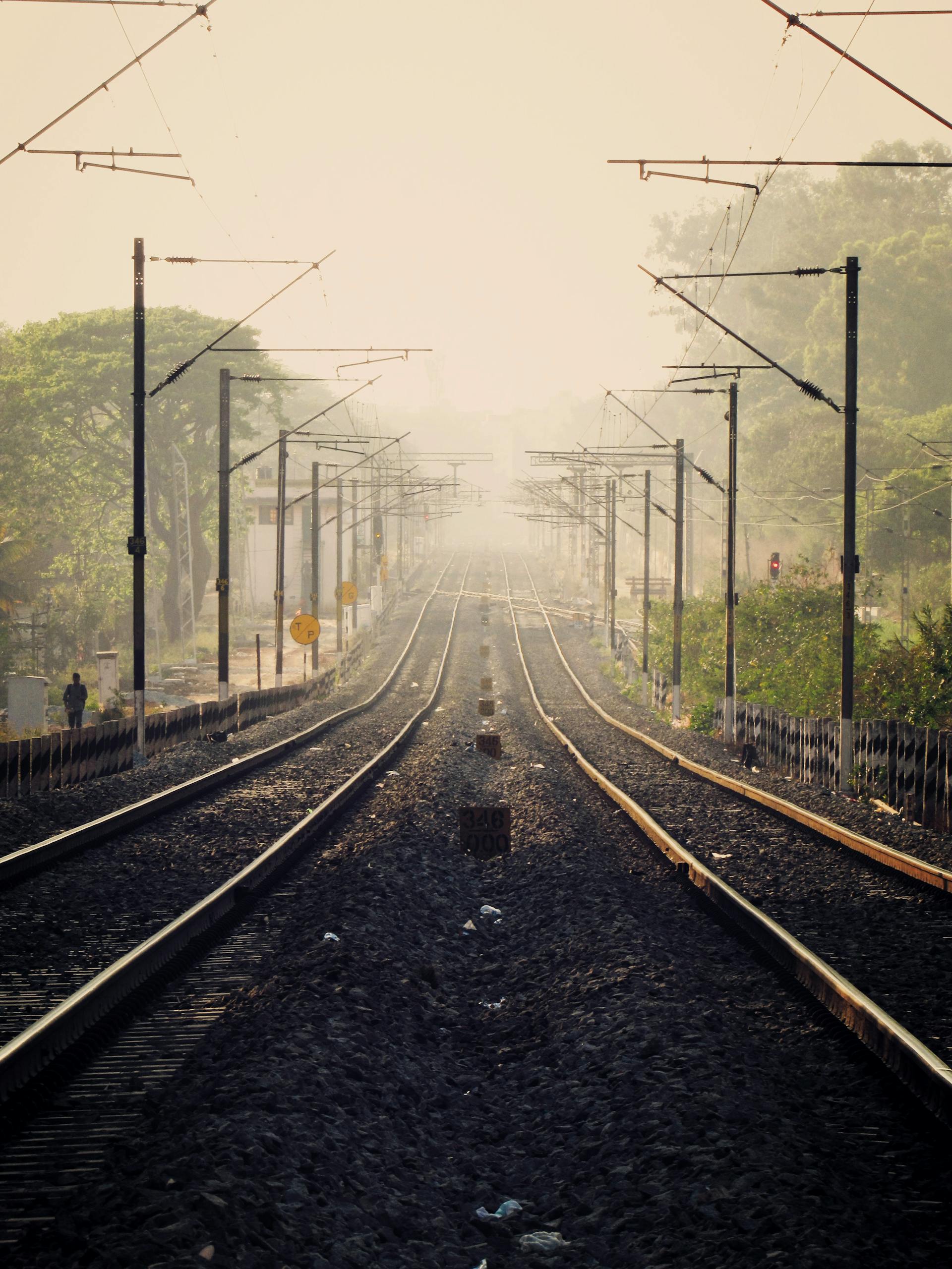 Symmetrical view of railway tracks vanishing into mist in Bengaluru.