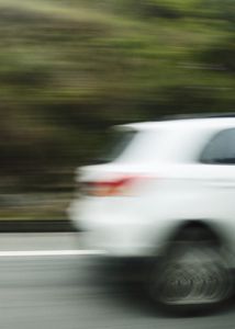 Blurry image of a car in motion on a highway, conveying speed and dynamism.